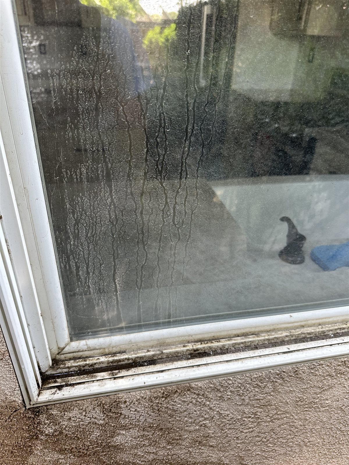 Sliding glass door with heavy hard water stains before treatment